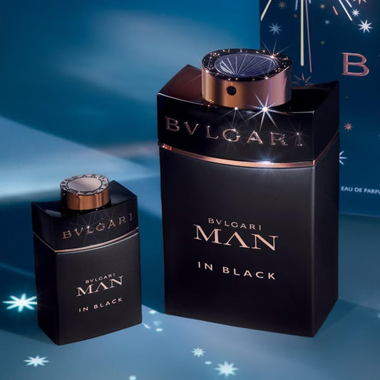 Bvlgari Man In Black fragrance gift set featuring full-size and travel-size black bottles with rose gold accents against a moody, star-lit winter background.