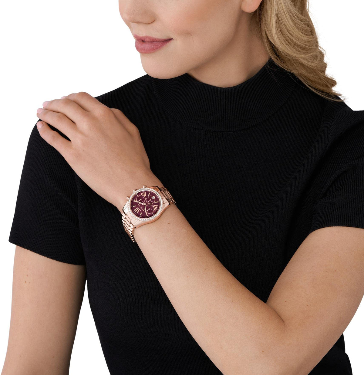 Editorial lifestyle portrait of a model wearing a sophisticated Michael Kors Lexington luxury watch on her wrist, dressed in a minimalist black top.