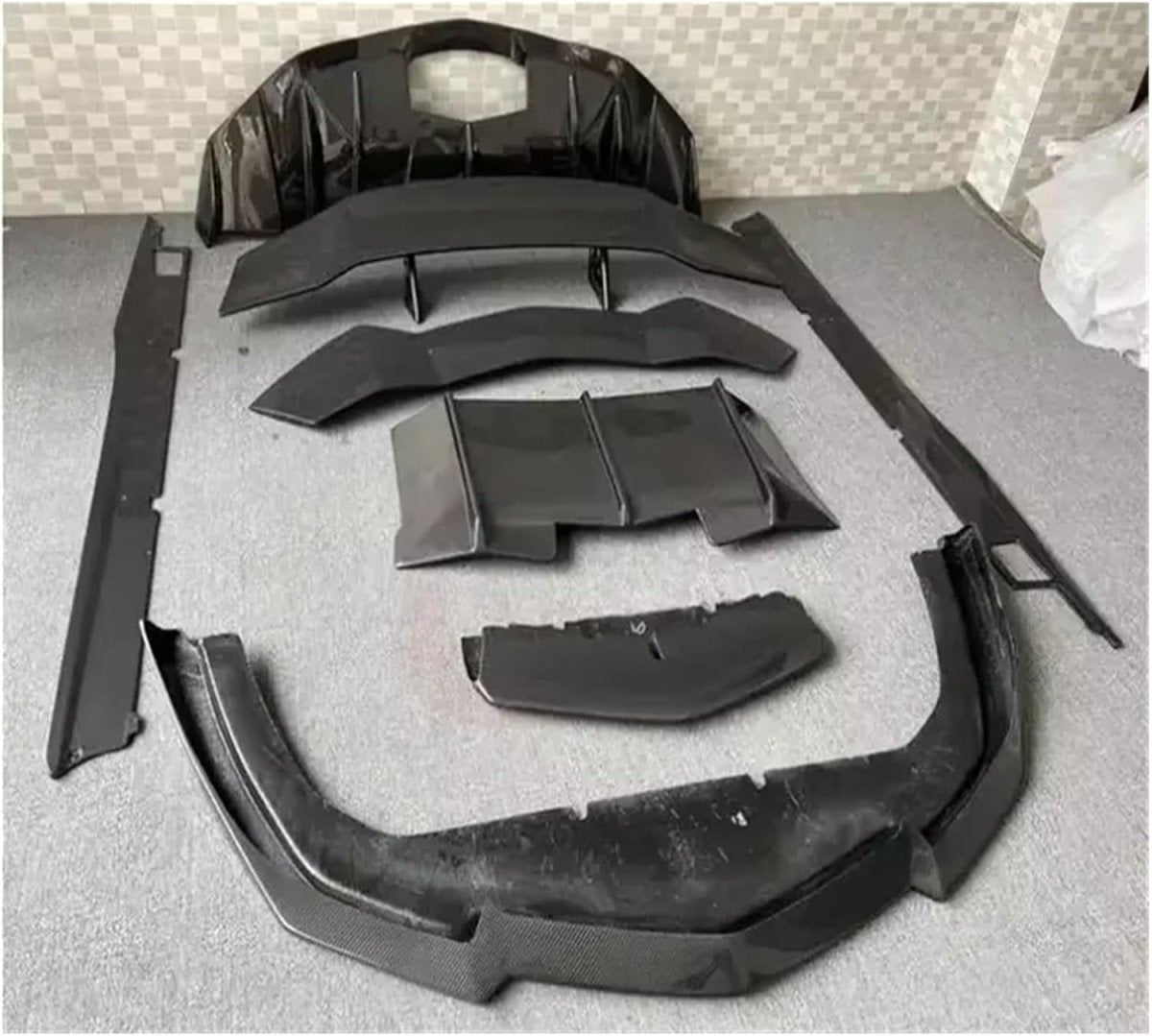 Detailed technical shot showing the sleek carbon fiber side skirt and aerodynamic components of the Lamborghini on display.