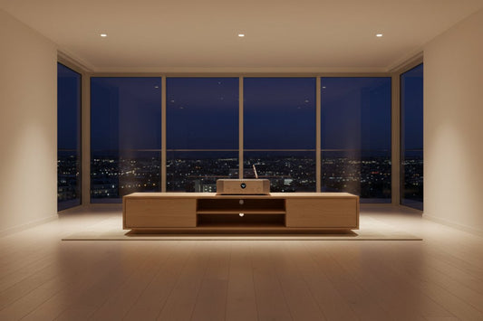Sleek audio equipment and media console placed in a minimalist high-rise interior with large glass windows overlooking a city skyline.
