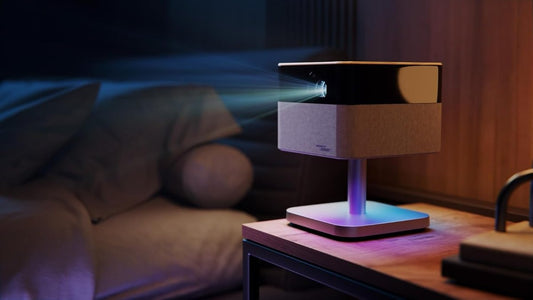 Innovative magnetic levitating portable projector glowing with atmospheric colored lights on a bedside table in a moody, modern room.
