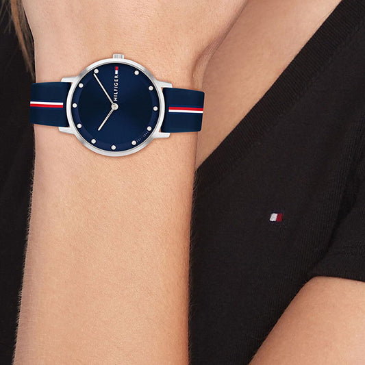 Women's Tommy Hilfiger watch with a deep blue dial and matching blue strap, worn elegantly on a wrist.